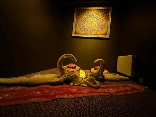 salle réservé aux massages thaï traditionnel. Un lit est décoré de serviettes avec une belle couverture.